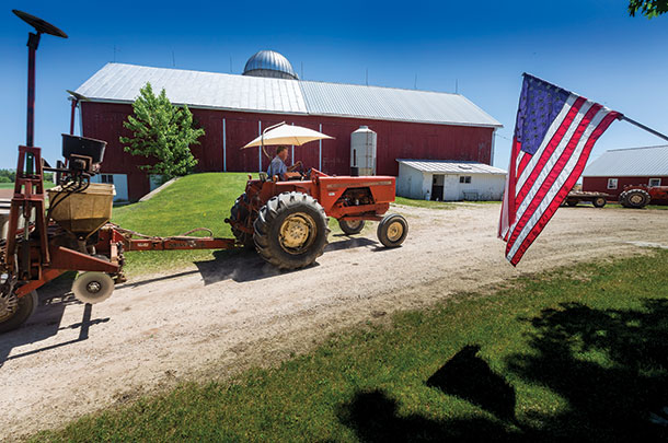 Jeff Wunrow passes an American flag as he heads in for another load of seed at his farm near Potter, Wisconsin.