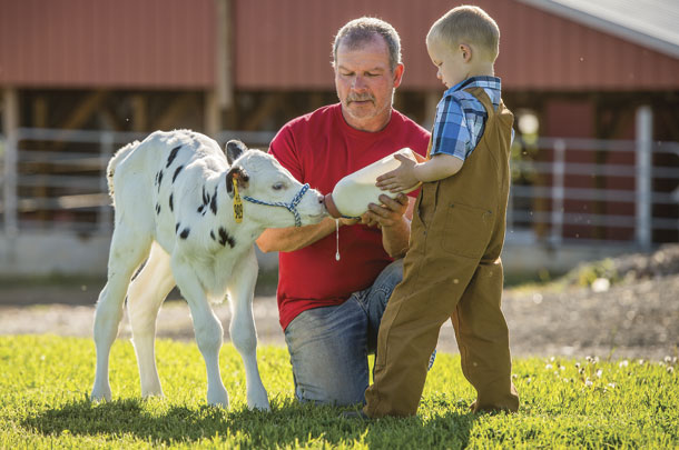 A Maryland dairy farmer helps his granson 